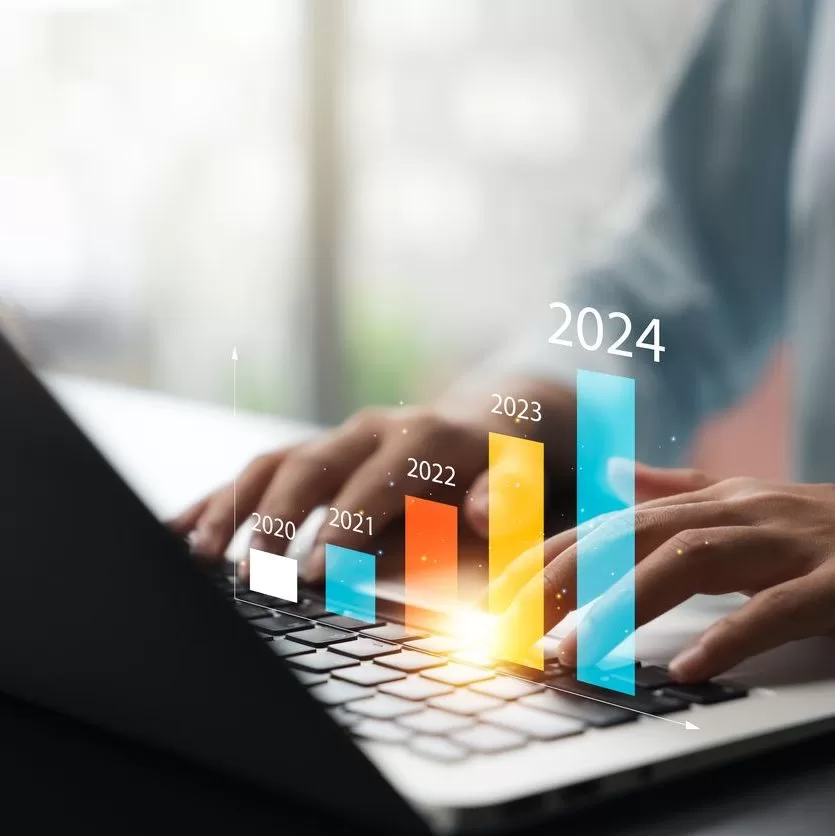 Person typing on a laptop keyboard with a virtual bar graph showing growth from 2020 to 2024, each year labeled on a bar, indicating increasing progress or business growth. - Lead Experts